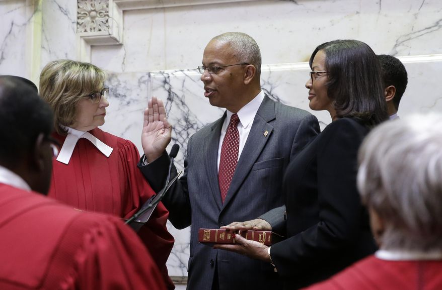Boyd Rutherford, center, accompanied by his wife Monica, takes the oath of office from from Mary Ellen Barbera, Chief Judge of the Maryland Court of Appeals, to become the Lt. Gov. of Maryland inside the state senate chamber, Wednesday, Jan. 21, 2015, before an inauguration ceremony in Annapolis, Md. (AP Photo/Patrick Semansky, Pool)