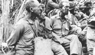 U.S. prisoners of war sit with their hands tied behind their backs during the Bataan Death March during World War II. (Image: U.S. Air Force)
