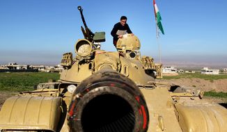 A Kurdish peshmerga stands on a military tank preparing for battle against the Islamic State group in northern Iraq, Jan. 20, 2015. (Associated Press) ** FILE **