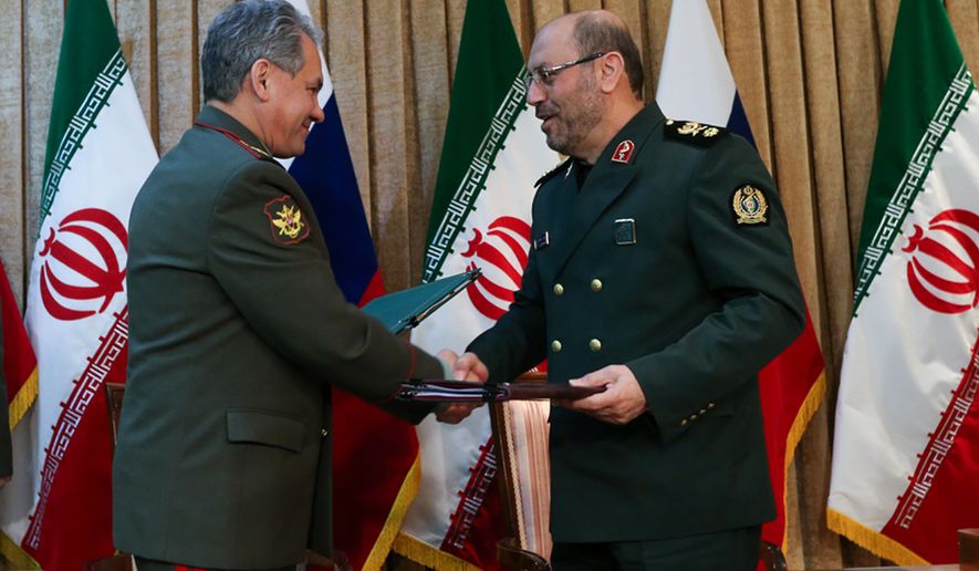 In this Tuesday, Jan. 20, 2015, photo Russia&#39;s Defense Minister Sergei Shoigu, left, and Iran&#39;s Defense Minister Hossein Dehghan exchange signed documents in Tehran, Iran. (AP Photo/ Vadim Savitsky, Russian Defense Ministry Press Service)