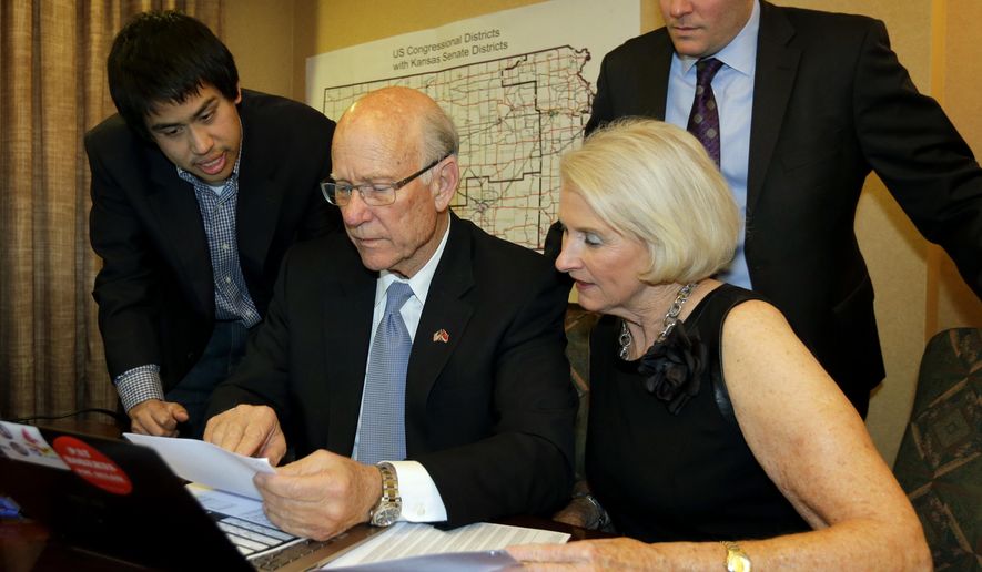 FILE-This Tuesday, Nov. 4, 2014 file photo shows Kansas Republican Sen. Pat Roberts with his wife Franki, campaign manager Corry Bliss, right, and field director Patrick Lee, left, looking over election results in his hotel room in Topeka, Kansas. P.G. Sittenfeld, a 30-year-old Cincinnati city councilman who says Ohio needs new leaders, is launching a 2016 Democratic bid for Republican U.S. Sen. Rob Portman’s seat in the swing state. Portman announced Thursday, Jan. 22, 2014 that Bliss, a veteran Republican strategist known for running aggressive campaigns will be his campaign manager. (AP Photo/Charlie Riedel, File)