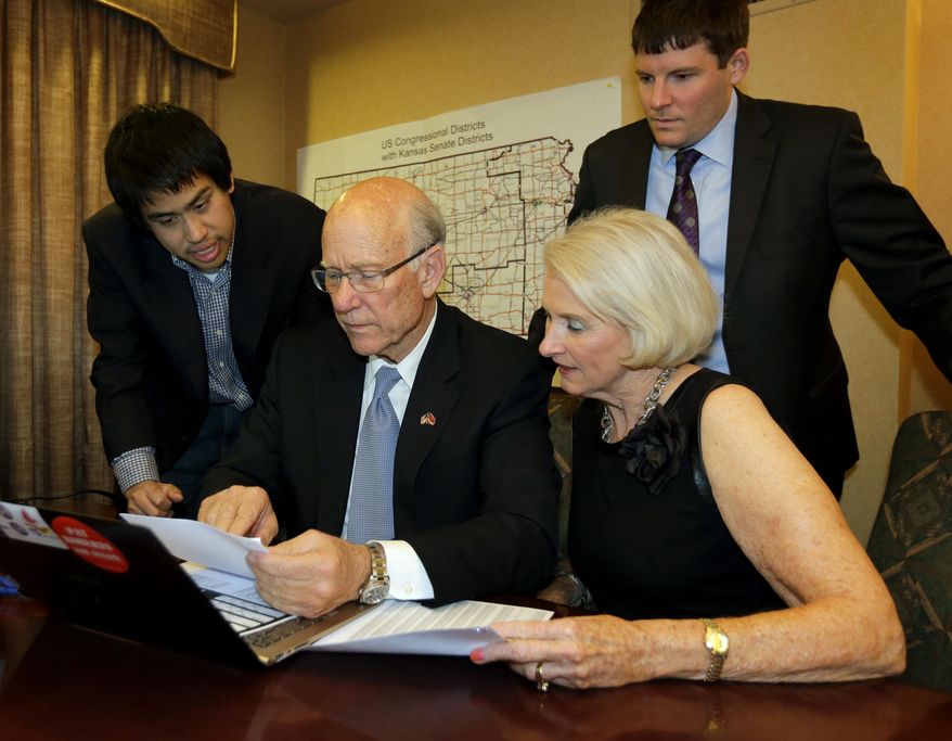 FILE-This Tuesday, Nov. 4, 2014 file photo shows Kansas Republican Sen. Pat Roberts with his wife Franki, campaign manager Corry Bliss, right, and field director Patrick Lee, left, looking over election results in his hotel room in Topeka, Kansas. P.G. Sittenfeld, a 30-year-old Cincinnati city councilman who says Ohio needs new leaders, is launching a 2016 Democratic bid for Republican U.S. Sen. Rob Portman’s seat in the swing state. Portman announced Thursday, Jan. 22, 2014 that Bliss, a veteran Republican strategist known for running aggressive campaigns will be his campaign manager. (AP Photo/Charlie Riedel, File)