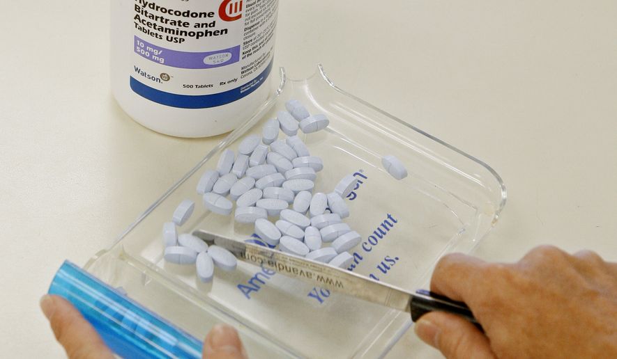 A pharmacy tech poses for a picture with hydrocodone bitartrate and acetaminophen tablets, the generic version of Vicodin, at Oklahoma Hospital Discount Pharmacy in Edmond, Okla., on Aug. 5, 2010. (Associated Press) **FILE**