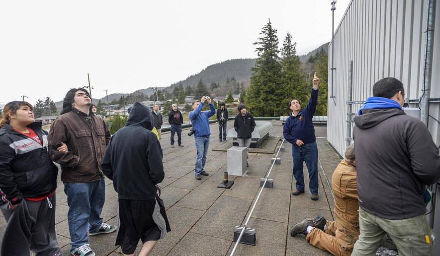 ADVANCE FOR SUNDAY, JAN. 25 AND THEREAFTER This Jan. 16, 2015 photo shows Ron Fortunato, president of Trillium Education, center, as he points to a weather monitor and explains to Ketchikan High School students how it is used to forecast earthquakes in Ketchikan, Alaska. It’s not quite rocket science, but close enough, and closer to home — students in the Tribal Scholars Program began cutting-edge earthquake monitoring research in a partnership with NASA this past week. (AP Photo/Ketchikan Daily News, Taylor Balkom)