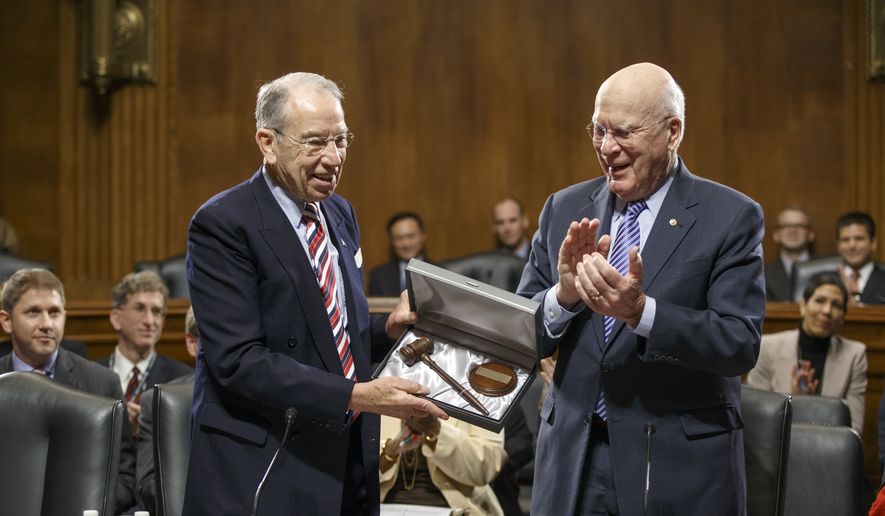 Sen. Patrick Leahy, D-Vt., center, the outgoing chairman of the Senate Judiciary Committee, applauds new committee chairman Sen. Chuck Grassley, R-Iowa, left, on Capitol Hill in Washington, Thursday, Jan. 22, 2015, after presenting Grassley a new gavel as the veteran senators hold an organizational meeting under the new Republican majority. (AP Photo/J. Scott Applewhite)