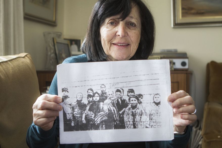 In this photo taken Thursday, Jan. 22, 2015, Marta Wise holds a famous black-and-white photo, taken by the Russian liberators of Auschwitz, showing her, center, with about a dozen children in rags standing behind a row of barbed wire that has become one of the most iconic images of the Holocaust, as she poses for a portrait in her house in Jerusalem. Wise was ill and emaciated when she heard the distant sound the soldiers marching toward Auschwitz. The 10-year-old Slovakian Jew assumed it was German troops coming to get her but once she saw the red stars on their uniforms she realized they were Russian. Her nightmare was over. She was liberated. (AP Photo/Dan Balilty)