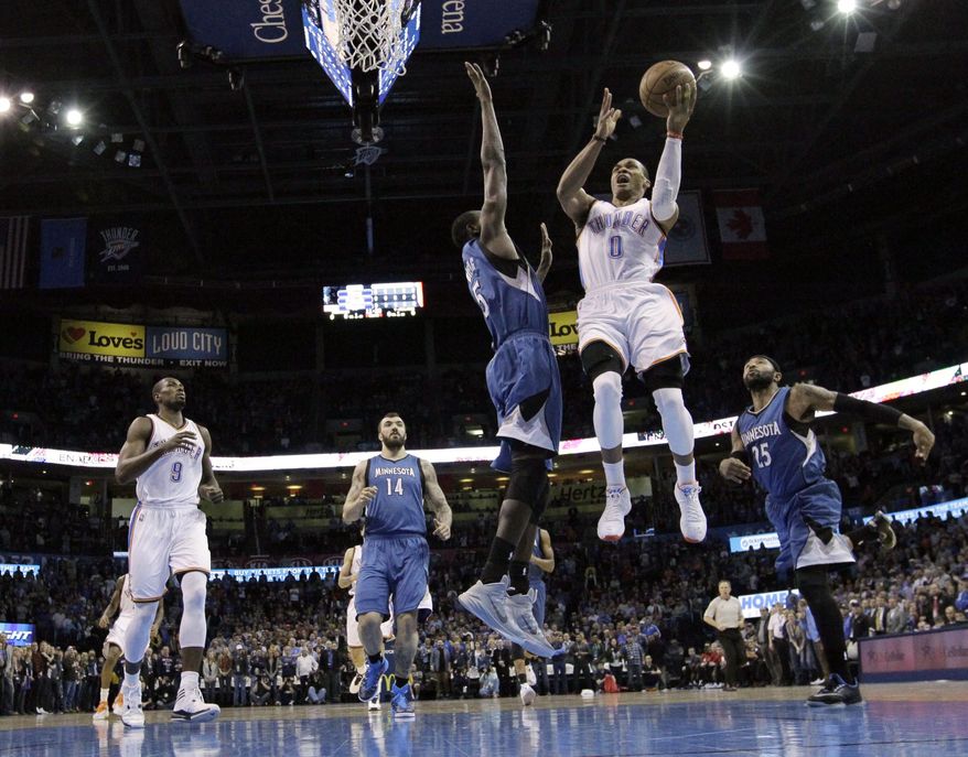 Oklahoma City Thunder guard Russell Westbrook (0) shoots in front of teammate Serge Ibaka (9), and Minnesota Timberwolves center Nikola Pekovic (14), center Gorgui Dieng (5) and guard Mo Williams (25) in the first quarter of an NBA basketball game in Oklahoma City, Monday, Jan. 26, 2015. (AP Photo/Sue Ogrocki)