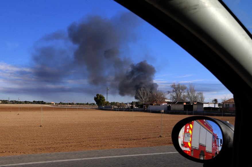 Smoke rises from a military base after a plane crash in Albacete, Spain, Monday, Jan. 26, 2015. A Greek F-16 fighter jet crashed into other planes on the ground during NATO training in southeastern Spain Monday, killing at least 10 people, Spain's Defense Ministry said. Another 13 people were injured in the incident at the Los Llanos base, which sent flames and a plume of black smoke billowing into the air, a Defense Ministry official said. (AP Photo/Josema Moreno)