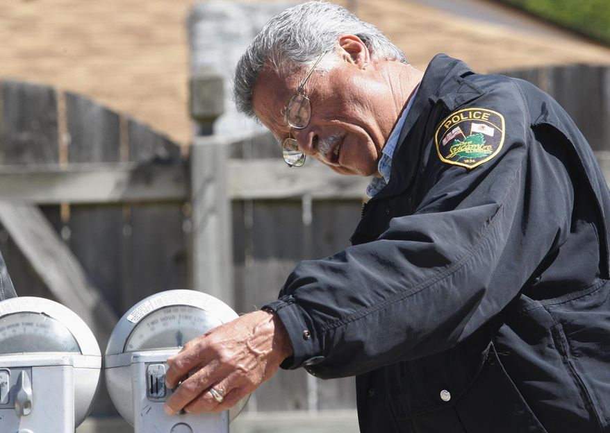 In this May 21, 2008 photo, parking enforcement officer Giovanni Serra looks at a penny parking meter in downtown Sycamore, Ill. The meters in the northern Illinois city may be running out of time. It is one of the few places in the country where penny parking meters are used, but city officials say the more than 300 meters that line downtown streets require timers from a company that no longer makes them. (AP Photo/Daily Chronicle, Eric Sumberg) CHICAGO TRIBUNE OUT, MANDATORY CREDIT