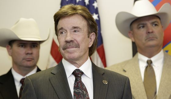 Actor Chuck Norris (center) looks on during a Dec. 2, 2010, ceremony in Garland, Texas, where he was made an honorary Texas Ranger. (Associated Press) **FILE**