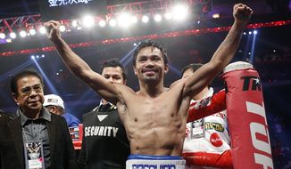 WBO welterweight champion Manny Pacquiao celebrates after defeating WBO junior welterweight champion Chris Algieri of the U.S.  during their welterweight title boxing match at the Venetian Macao in Macau, Sunday, Nov. 23, 2014. Pacquiao got the big knockdowns he desperately craved, battering Algieri around the ring Sunday on his way to a decision win in a lopsided welterweight title fight.(AP Photo/Kin Cheung)