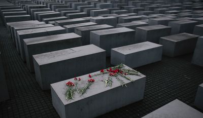 Flowers lie  on a concrete slab of the Holocaust Memorial to mark the International Holocaust Remembrance Day and commemorating the 70th anniversary of the liberation of the Nazi Auschwitz death camp in Berlin, Tuesday, Jan. 27, 2015. (AP Photo/Markus Schreiber)
