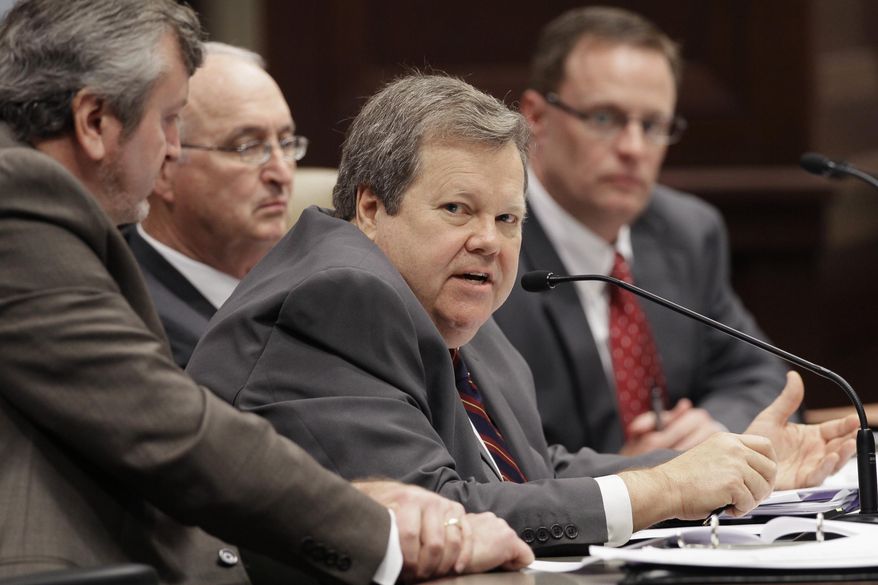 Tim Leathers of the Arkansas Department of Finance and Administration, center, answers legislators' questions as, from left, John Shelnutt, department director Larry Walther, and Brandon Sharp, far right, listen in a meeting of the Joint Budget Committee at the Arkansas state Capitol in Little Rock, Ark., Tuesday, Jan. 27, 2015. (AP Photo/Danny Johnston)