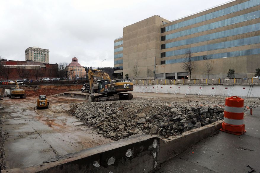In this Jan. 26, 2015 photo, heavy machinery nears completion of the removal of a 1960s-era parking garage in downtown Asheville, N.C. A developer will begin constructing a nine-story, upscale hotel with retail along the street _ circling back to what was there before the '60s. Communities across the country are demolishing the garages and putting up buildings again, confident that more people will be drawn to lively offices, hotels and housing. (AP Photo/The Citizen-Times, William Woody)