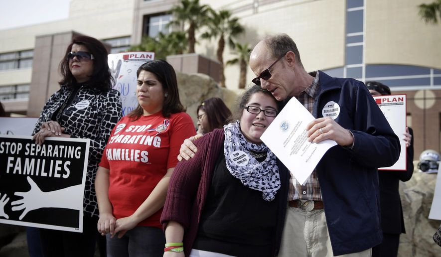 Bob Fulkerson, right, embraces Dulce Valencia during a protest Wednesday, Jan. 28, 2015, in Las Vegas. They are part of a group that was demanding that Nevada Attorney General Adam Laxalt drop a lawsuit against President Barack Obama&#39;s immigration action. (AP Photo/John Locher)