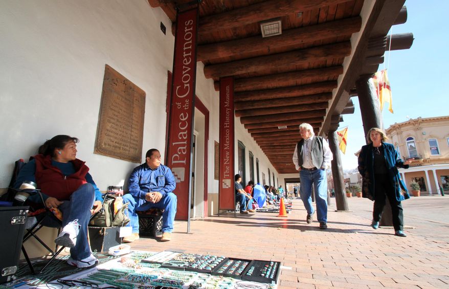 Donna and Joseph Nieto, left, of Santo Domingo Pueblo, N.M., sit under the portal at the Palace of the Governors as they sell their jewelry to passersby in Santa Fe, N.M., on Wednesday, Jan. 28, 2015. The Palace of the Governors, the oldest continuously occupied public building in the U.S., was added to the National Trust for Historic Preservation's list of national treasures on Wednesday in hopes of garnering attention and funding for much-needed repairs. (AP Photo/Susan Montoya Bryan)
