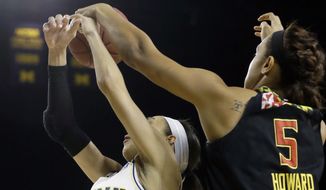 Maryland center Malina Howard (5) knocks the ball away from Michigan guard Shannon Smith (5) during the first half of an NCAA college basketball game, Thursday, Jan. 29, 2015 in Ann Arbor, Mich. (AP Photo/Carlos Osorio)