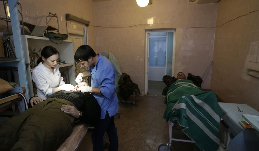 An injured Ukrainian soldier receives medical care at a hospital in the town of Artemivsk, Ukraine, Thursday, Jan. 29, 2015. Fighting between government and Russian-backed separatist forces in eastern Ukraine has intensified in recent days as rebels seek to encircle the town of Debaltseve, which hosts a strategically important railway hub. (AP Photo/Petr David Josek)