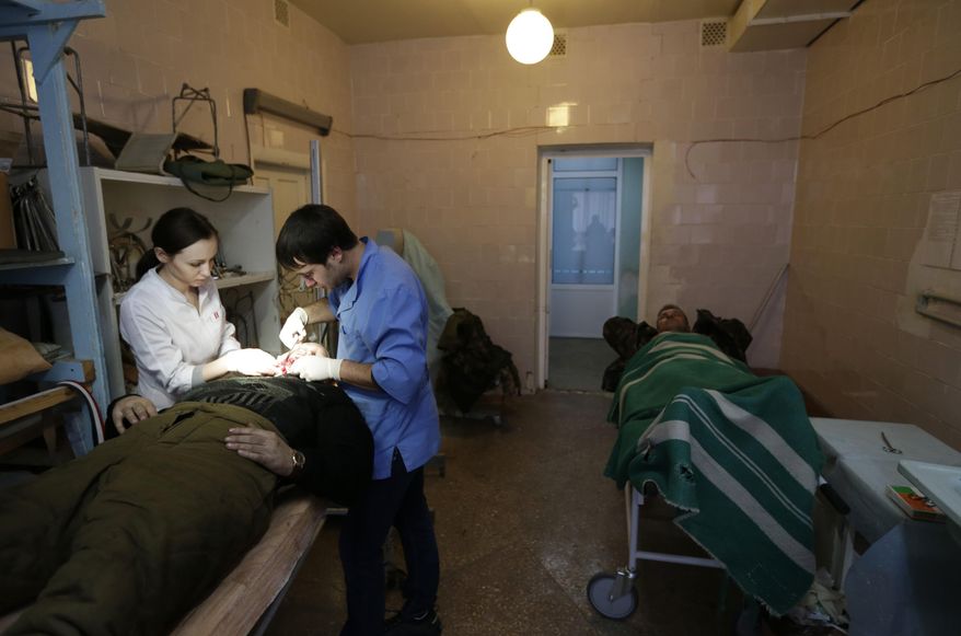 An injured Ukrainian soldier receives medical care at a hospital in the town of Artemivsk, Ukraine, Thursday, Jan. 29, 2015. Fighting between government and Russian-backed separatist forces in eastern Ukraine has intensified in recent days as rebels seek to encircle the town of Debaltseve, which hosts a strategically important railway hub. (AP Photo/Petr David Josek)