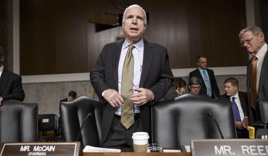 Senate Armed Services Committee Chairman Sen.John McCain, R-Ariz., stands up at the start of a hearing with former Secretary of State Henry A. Kissinger, Thursday, Jan. 29, 2015, on Capitol Hill in Washington. Protesters interrupted the start of a Senate Armed Services hearing as they shouted at Kissinger, calling him a war criminal. Sen. James Inhofe, R-Okla., is at right. (AP Photo/J. Scott Applewhite)