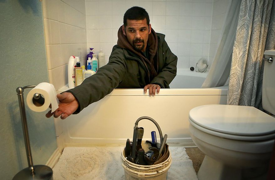 In this photo taken on Thursday, Jan. 15, 2015, Anthony Cartagena, who is a plumber with Parker & Sons Plumbing, works cleaning out a bath tub drain in a client's home, in San Antonio, Texas. A master plumber, Cartagena learned the craft from his father-in-law, instead of following his own father into a life of street crime. (AP Photo/The San Antonio Express-News, Bob Owen ) RUMBO DE SAN ANTONIO OUT; NO SALES
