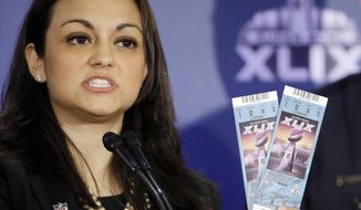 NFL Counsel Dolores F. Dibella holds up Super Bowl tickets to show the security features on them during a counterfeit ticket and merchandise news conference for NFL Super Bowl XLIX football game Thursday, Jan. 29, 2015, in Phoenix. (AP Photo/David J. Phillip)