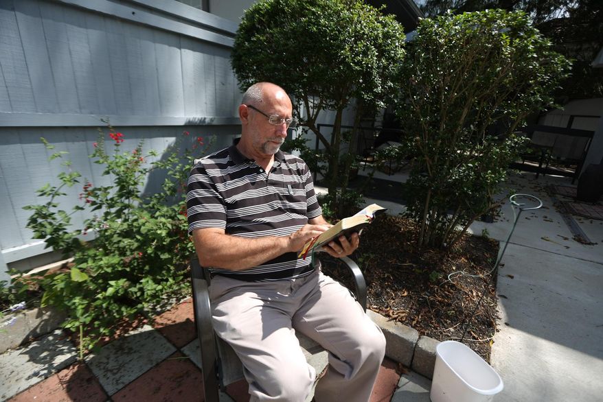 ADVANCED FOR RELEASE SATURDAY, JANUARY 31, 2015 AND THEREAFTER Tom Soper, 63, of Lewisburg, reads the Bible in the backyard of the West Virginia Institute of Spirituality, Friday, Sept. 5, 2014, in Charleston, W.Va. (AP Photo/Charleston Daily Mail, Marcus Constantino)