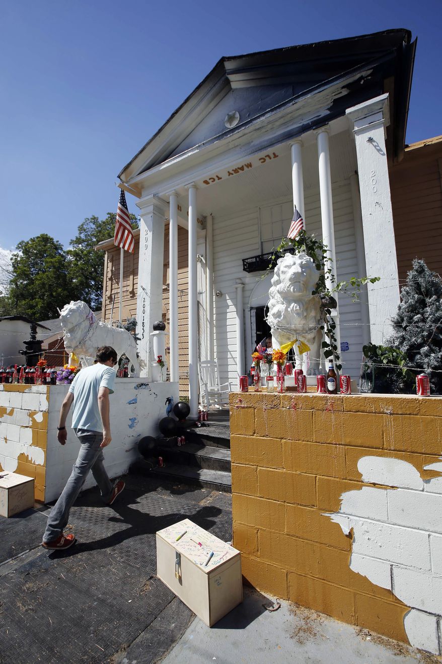 FILE - In this Aug. 12, 2014, file photo, a visitor walks up the front steps of Graceland Too, an offbeat museum in Holly Springs, Miss., dedicated to Elvis Presley and owned by the late Paul MacLeod, an Elvis-obsessed man. The contents and house will be auctioned Saturday, Jan. 31, 2015. MacLeod died last summer. (AP Photo/Rogelio V. Solis, File)