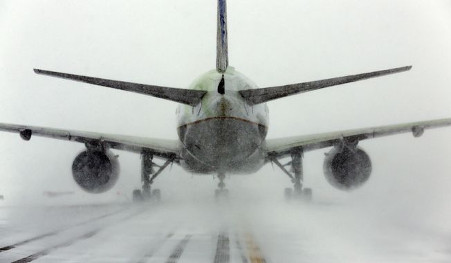 A United Airlines jet blows snow on a runway at O&#x27;Hare International Airport, Sunday, Feb. 1, 2015, in Chicago. More than 1,100 flights have been canceled at Chicago&#x27;s airports and snow-covered roads are making travel treacherous. (AP Photo/Nam Y. Huh)