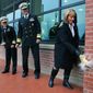 Vice Adm. Willy Hilarides (center) watches his wife Beverly break a bottle against the wall during the reopening ceremony for the Naval Sea Systems Command&#39;s headquarters building at the Washington Navy Yard. On the far left is Rear Admiral Katherine L. Gregory. The building was the site of the shooting rampage on Sept. 16, 2013. (U.S. Navy)