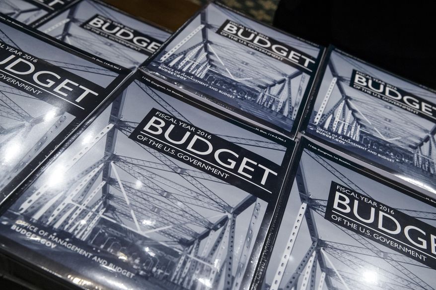 President Barack Obama's new $4 trillion budget plan is distributed by Senate Budget Committee staffer Eric Chalmers as it arrives on Capitol Hill in Washington, early Monday, Feb. 02, 2015. The fiscal blueprint for the budget year that begins Oct. 1, seeks to raise taxes on wealthier Americans and corporations and use the extra income to lift the fortunes of families who have felt squeezed during tough economic times. Republicans, who now hold the power in Congress, are accusing the president of seeking to revert to tax-and-spend policies that will harm the economy while failing to do anything about soaring spending on government benefit programs. (AP Photo/J. Scott Applewhite)