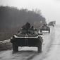 Ukranian military vehicles are seen driving on the road towards the town of Artemivsk, Ukraine, Sunday, Feb. 1, 2015. Fighting between government and Russian-backed separatist forces in eastern Ukraine has intensified in recent days as rebels seek to encircle the town of Debaltseve, which hosts a strategically important railyway hub. (AP Photo/Petr David Josek)