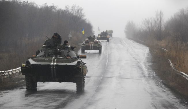 Ukranian military vehicles are seen driving on the road towards the town of Artemivsk, Ukraine, Sunday, Feb. 1, 2015. Fighting between government and Russian-backed separatist forces in eastern Ukraine has intensified in recent days as rebels seek to encircle the town of Debaltseve, which hosts a strategically important railyway hub. (AP Photo/Petr David Josek)