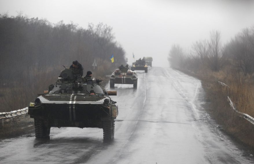 Ukranian military vehicles are seen driving on the road towards the town of Artemivsk, Ukraine, Sunday, Feb. 1, 2015. Fighting between government and Russian-backed separatist forces in eastern Ukraine has intensified in recent days as rebels seek to encircle the town of Debaltseve, which hosts a strategically important railyway hub. (AP Photo/Petr David Josek)