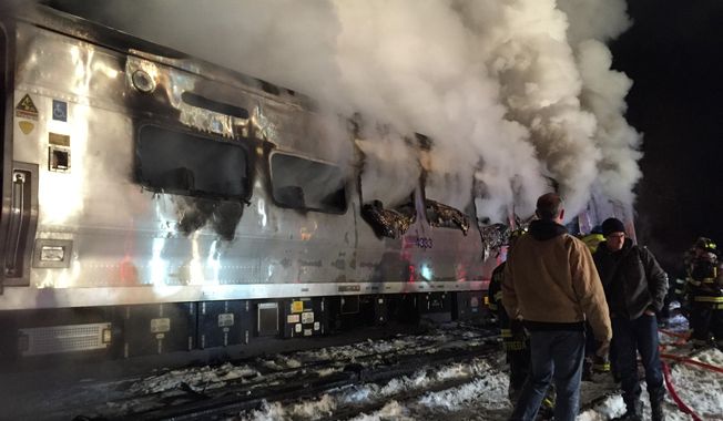 A Metro-North Railroad passenger train smolders after hitting a vehicle in Valhalla, N.Y., Tuesday, Feb. 3, 2015. (AP Photo/The Journal News, Frank Becerra Jr) 