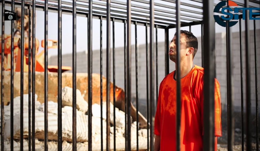 This still image made from video released by Islamic State group militants and posted on the website of the SITE Intelligence Group on Tuesday, Feb. 3, 2015, purportedly shows Jordanian pilot Lt. Muath al-Kaseasbeh standing in a cage just before being burned to death by his captors. The death of the 26-year-old pilot, who fell into the hands of the militants in December when his Jordanian F-16 crashed near Raqqa, Syria, followed a weeklong drama over a possible prisoner exchange. (AP Photo/SITE Intelligence Group)