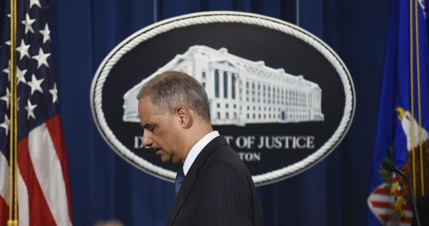 Attorney General Eric Holder steps away from the podium at a news conference at the Department of Justice on Tuesday, Feb. 3, 2015 in Washington. (AP Photo/Kevin Wolf)