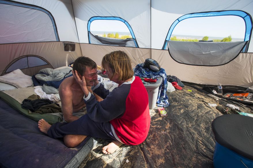 Kevin Kurtz and Darcy Robertson sit in their tent on the beach Thursday, Jan. 29, 2015, on the Bolivar Peninsula in Texas. Kurtz, 51, and Robertson, 54, were surprised to learn that camps such as theirs are among the reasons Galveston County is seeking legislative authority to regulate peninsula beaches. They say they have kept out of trouble and pride themselves in the cleanliness of their encampment, but complaints about long-term campers over the years led commissioners to seek the new authority. (AP Photo/Houston Chronicle, Brett Coomer) MANDATORY CREDIT