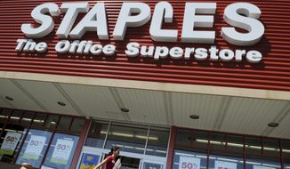 FILE - In this May 26, 2009 file photo, a woman walks past a Staples office supply store in Danvers, Mass. Staples on Wednesday, Feb. 4, 2015 announced it is buying Office Depot in a cash-and-stock deal valued at nearly $6 billion. (AP Photo/Lisa Poole, File)