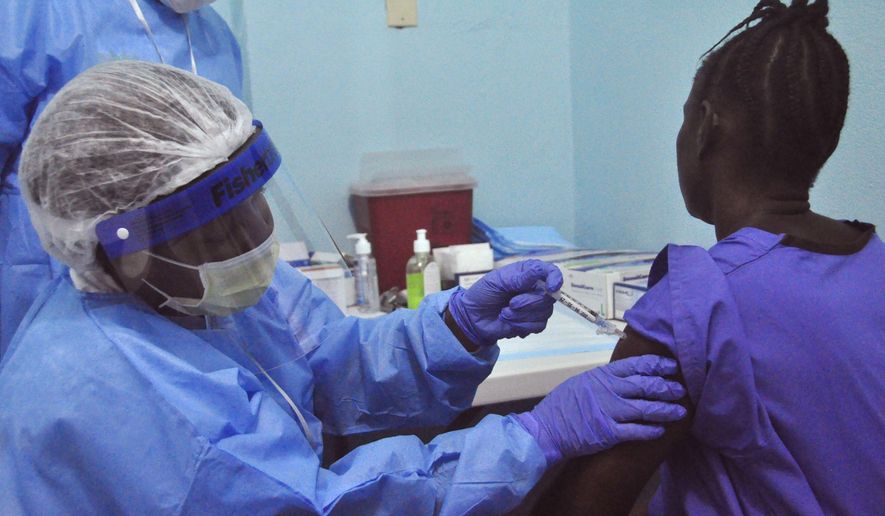 A woman is injected by a health care worker, left, as she takes part in an Ebola virus vaccine trial, at one of the largest hospital&#39;s Redemption hospital in Monrovia, Liberia, Monday, Feb. 2, 2015. A large-scale human trial of two potential Ebola vaccines got under way in Liberia&#39;s capital Monday, part of a global effort to prevent a repeat of the epidemic that has now claimed nearly 9,000 lives in West Africa. (AP Photo/Abbas Dulleh)