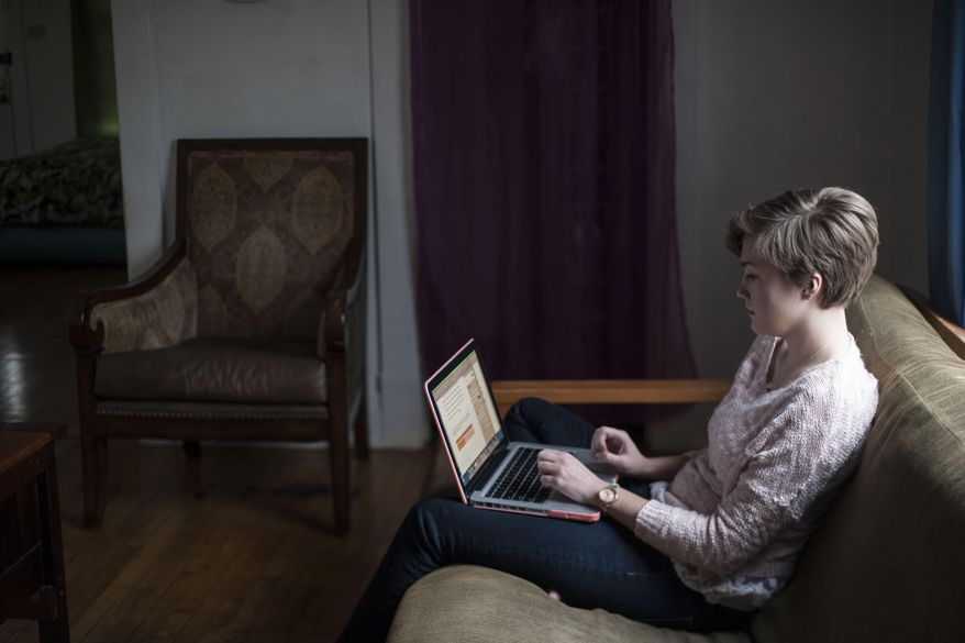 ADVANCED FOR RELEASE MONDAY, FEBRUARY 9, 2015 Kelly Rothe, 21, an Eastern Michigan University student who had a double mastectomy last May, writes a paper on her laptop for school on Friday, Dec. 5, 2014, in Ann Arbor, Mich. (AP Photo/The Ann Arbor News, Katie McLean)