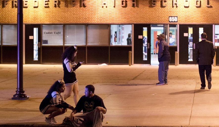 People gather outside the entrance to Frederick High School following a shooting in Frederick, Md., Wednesday, Feb. 4, 2015. Police and school officials said students were shot outside the school while a basketball game was being played inside. (AP Photo/The Frederick News-Post, Bill Green)