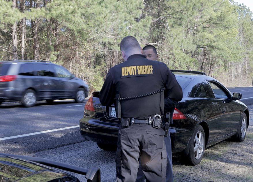 Senior Cpl. Bryan Rulong interviews a driver he stopped for speeding on 1-95 S in Sumter County, S.C. on Jan. 30, 2015. Every day an army of smugglers traffic illegal narcotics and large amounts of cash, using the 1,900-mile artery to ferry their stashed loads through the county, state and region. Drug experts say the I-95 pipeline is notorious for the role it plays in the American drug trade and has been so for decades. (AP Photo/The Item, Keith Gedamke)