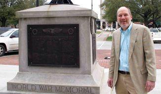 In this Jan. 22, 2015, photo, Greenwood Mayor Welborn Adams stands beside the Greenwood County memorial in Greenwood, S.C., that honors its citizens who died in recent wars. The World War I and World War II soldiers are separated into colored and white. Adams raised $15,000 to put new plaques on the statue, but a state law won&#39;t allow him to put them up. (AP Photo/Jeffrey Collins)