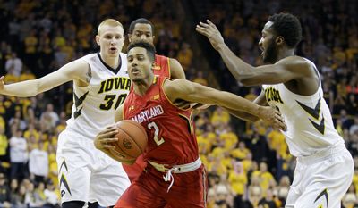 Maryland guard Melo Trimble drives to the basket past Iowa center Gabriel Olaseni (right) on Sunday. (Associated Press)