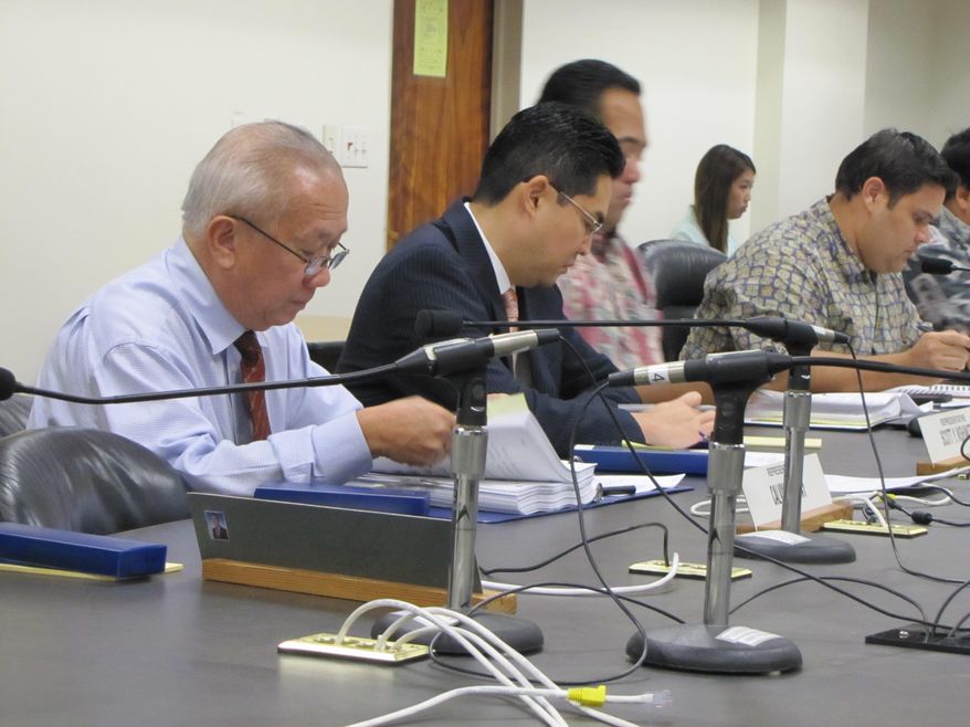 Rep. Calvin Say, left, listens during a meeting of the House Committee on Water and Land at the Hawaii Legislature on Monday, Feb. 9, 2015 in Honolulu, Hawaii. The Hawaii House of Representatives has convened a special committee to hear a challenge brought by voters who argue that Say doesn't live in the district he represents. (AP Photo/Cathy Bussewitz)