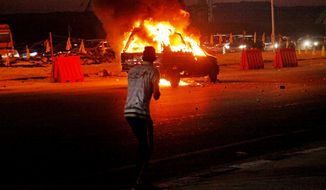 An Egyptian looks at a vehicle lit on fire during a riot outside the Air Defense Stadium in a suburb east of Cairo, Egypt, in this Sunday, Feb. 8, 2015, photo. Egypt&#x27;s Cabinet has indefinitely suspended the national soccer league after more than 20 fans were killed in a stampede and clashes with police outside the Cairo stadium. (AP Photo/Ahmed Abd El-Gwad, El Shorouk Newspaper)