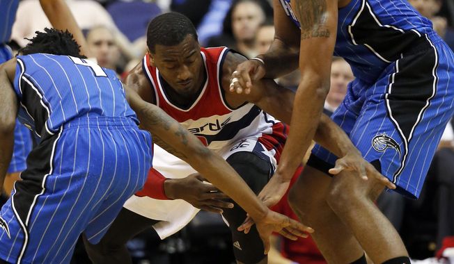 Washington Wizards guard John Wall (2) has trouble controlling the ball as Orlando Magic guard Elfrid Payton (4) and forward Channing Frye (8) go for the steal in the first half of an NBA basketball game Monday, Feb. 9, 2015, in Washington. (AP Photo/Alex Brandon)