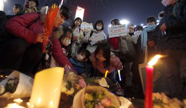 In this Sunday, Feb. 8, 2015, file photo, people gather to mourn two Japanese hostages, Kenji Goto and Haruna Yukawa, who were killed by the Islamic State group, in Tokyo. (AP Photo/Shizuo Kambayashi)