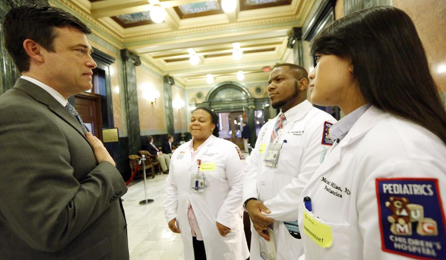 Dr. Mariel Milan, right, joins other pediatric residents from the University of Mississippi Medical Center as they confer with state Sen. Will Longwitz, R-Madison, about childhood vaccinations during a visit to the Capitol, Tuesday, Feb. 10, 2015, in Jackson, Miss. According to the Centers for Disease Control and Prevention, Mississippi has the highest measles immunization rate in the country for children entering kindergarten. (AP Photo/Rogelio V. Solis)